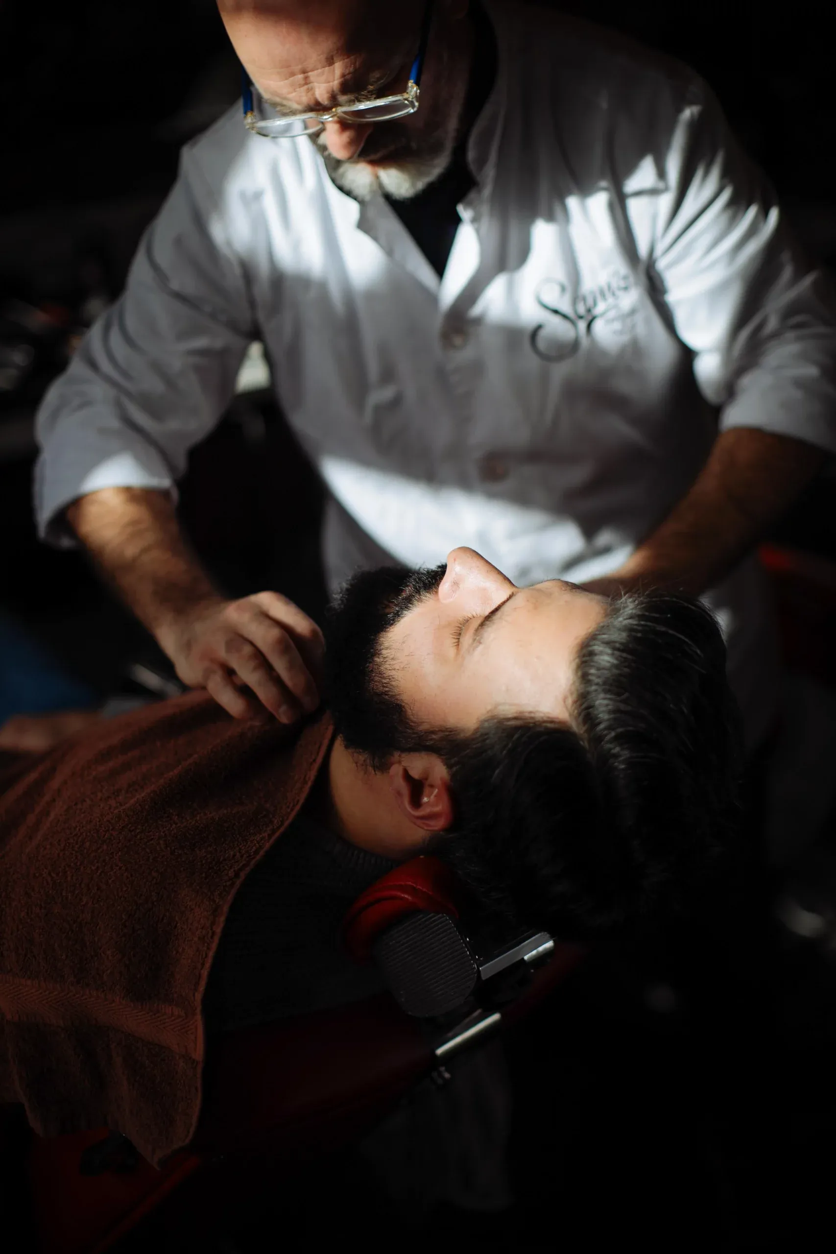 A barber giving a hot-towel shave